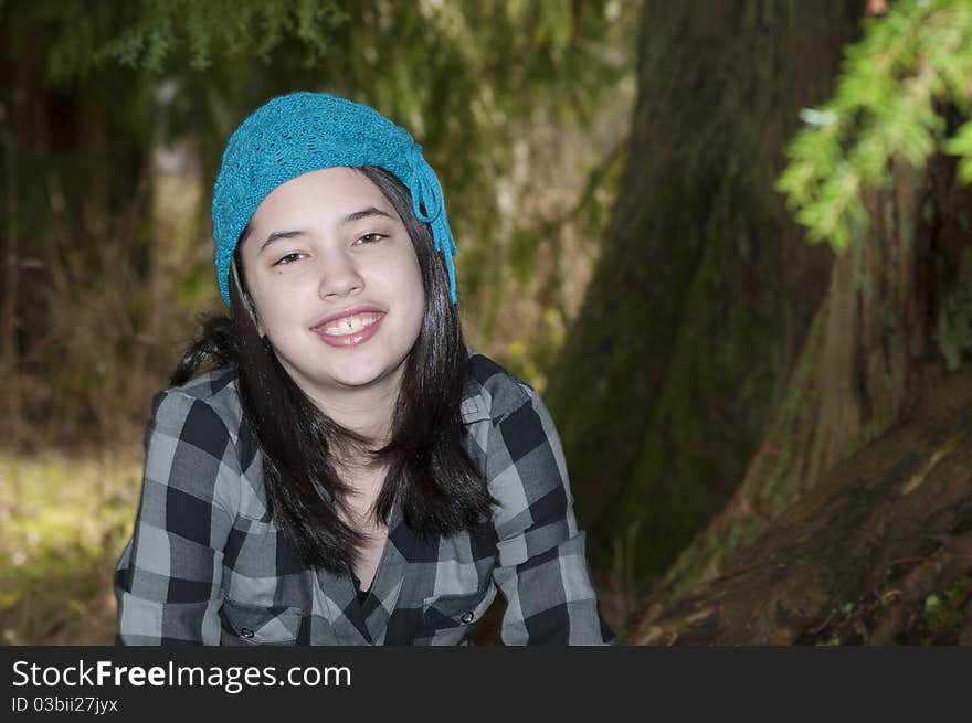 Young preteen girl wearing a flannel shirt in the forest. Young preteen girl wearing a flannel shirt in the forest