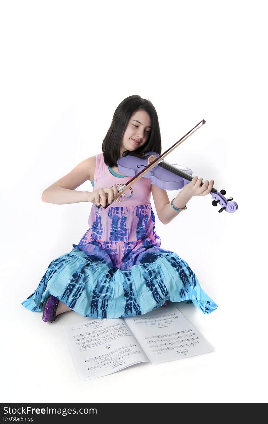 Preteen girl playing a purple violin in tie dye dress. Preteen girl playing a purple violin in tie dye dress