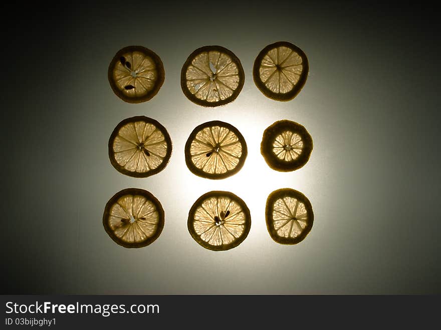 Nine lemon slices in a sqaure lit from behind. Nine lemon slices in a sqaure lit from behind.