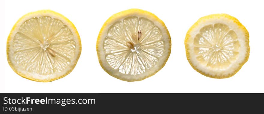 Three fresh yellow lemons slices on a white isolated background. Three fresh yellow lemons slices on a white isolated background.