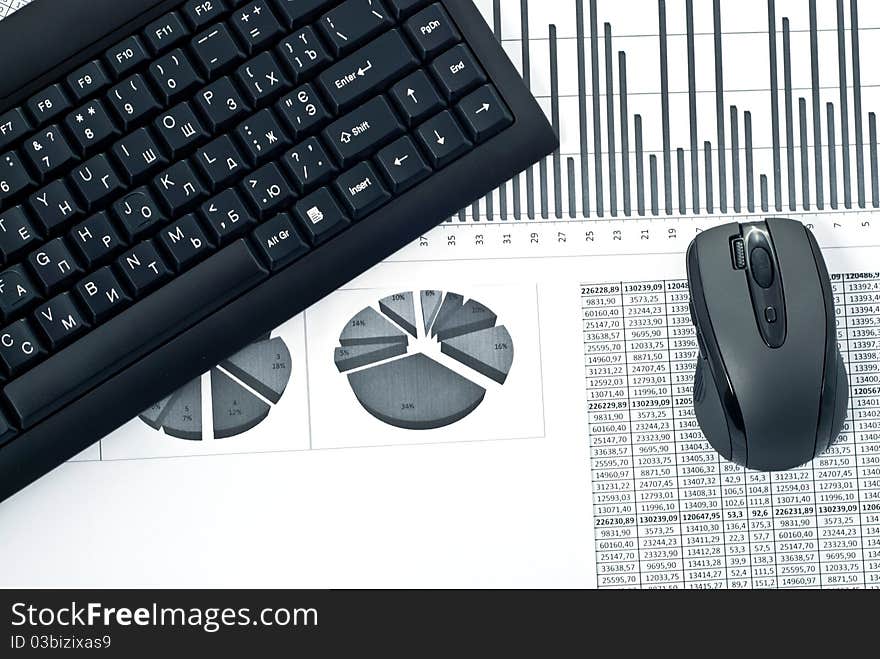 Black keyboard and mouse on a stock chart. Black keyboard and mouse on a stock chart.