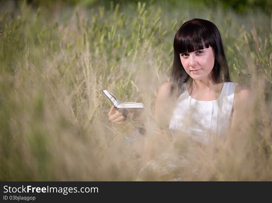 Girl reading a book in the grass