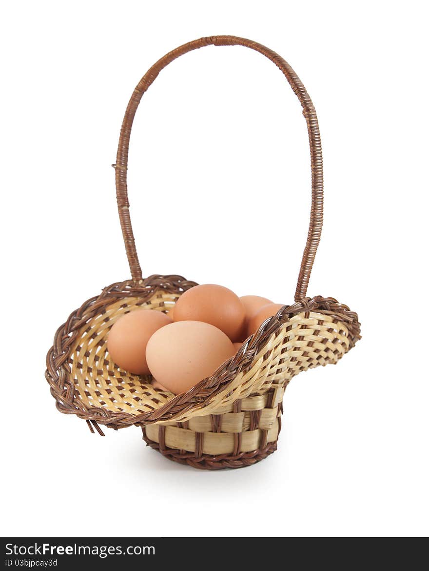 Easter eggs in brown basket on a white background