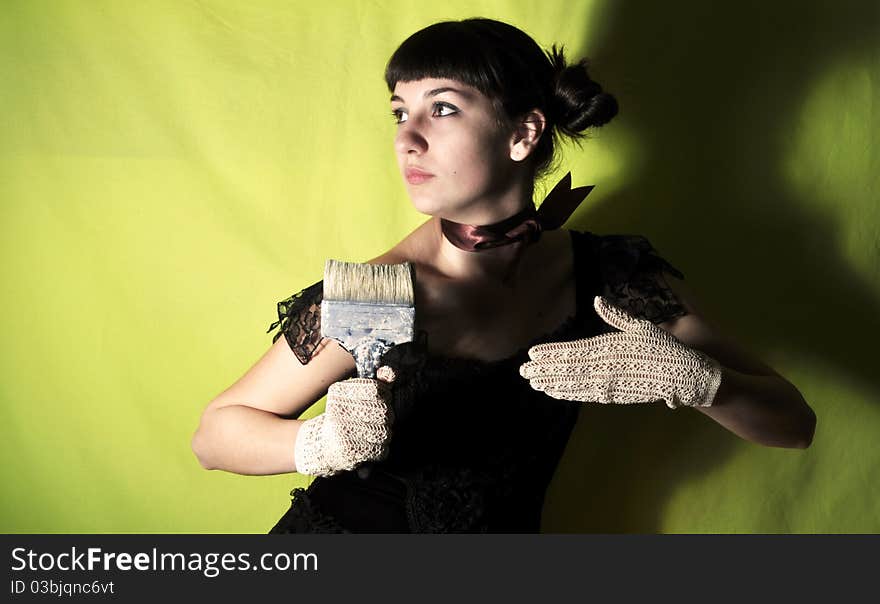 Attractive brunette girl in black dress holding paintbrush. Attractive brunette girl in black dress holding paintbrush