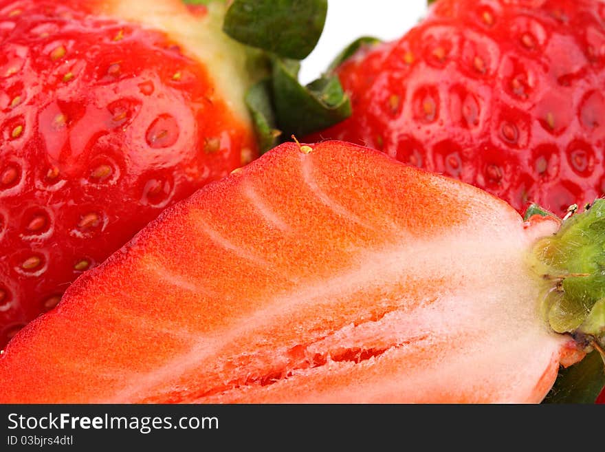 A closeup of slice of strawberry and whole fruits. A closeup of slice of strawberry and whole fruits.