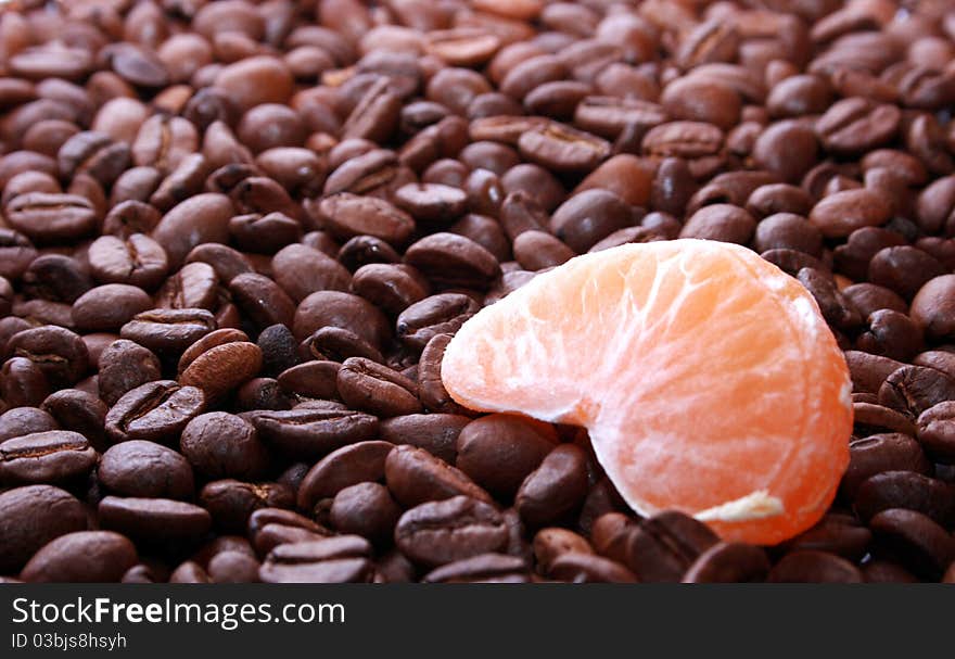 Lobule of mandarin on the corns of coffee. Lobule of mandarin on the corns of coffee