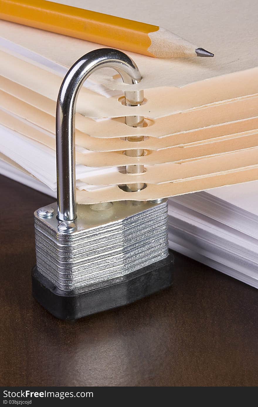 Stack of manila folders closed with a metal lock. Stack of manila folders closed with a metal lock.