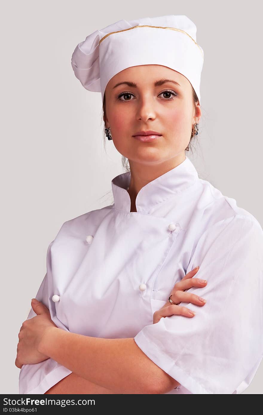 Young woman in white chef dress with hat. Young woman in white chef dress with hat