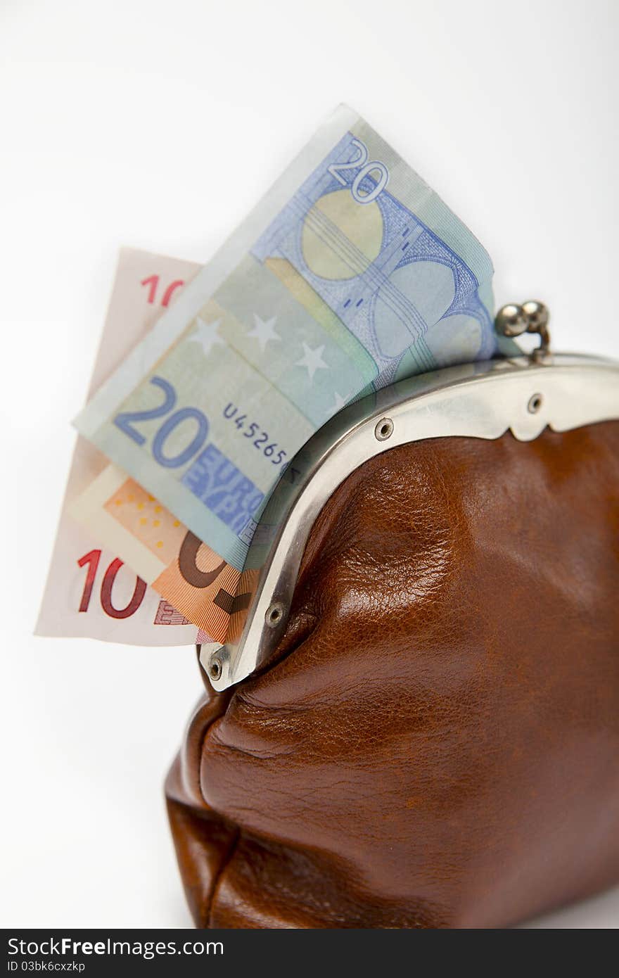 Closeup of an old brown leather changing purse with money sticking out. Closeup of an old brown leather changing purse with money sticking out