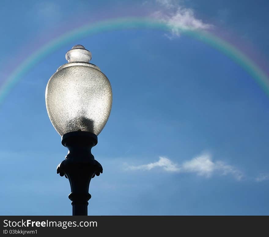 Lamppost with Rainbow against blue sky