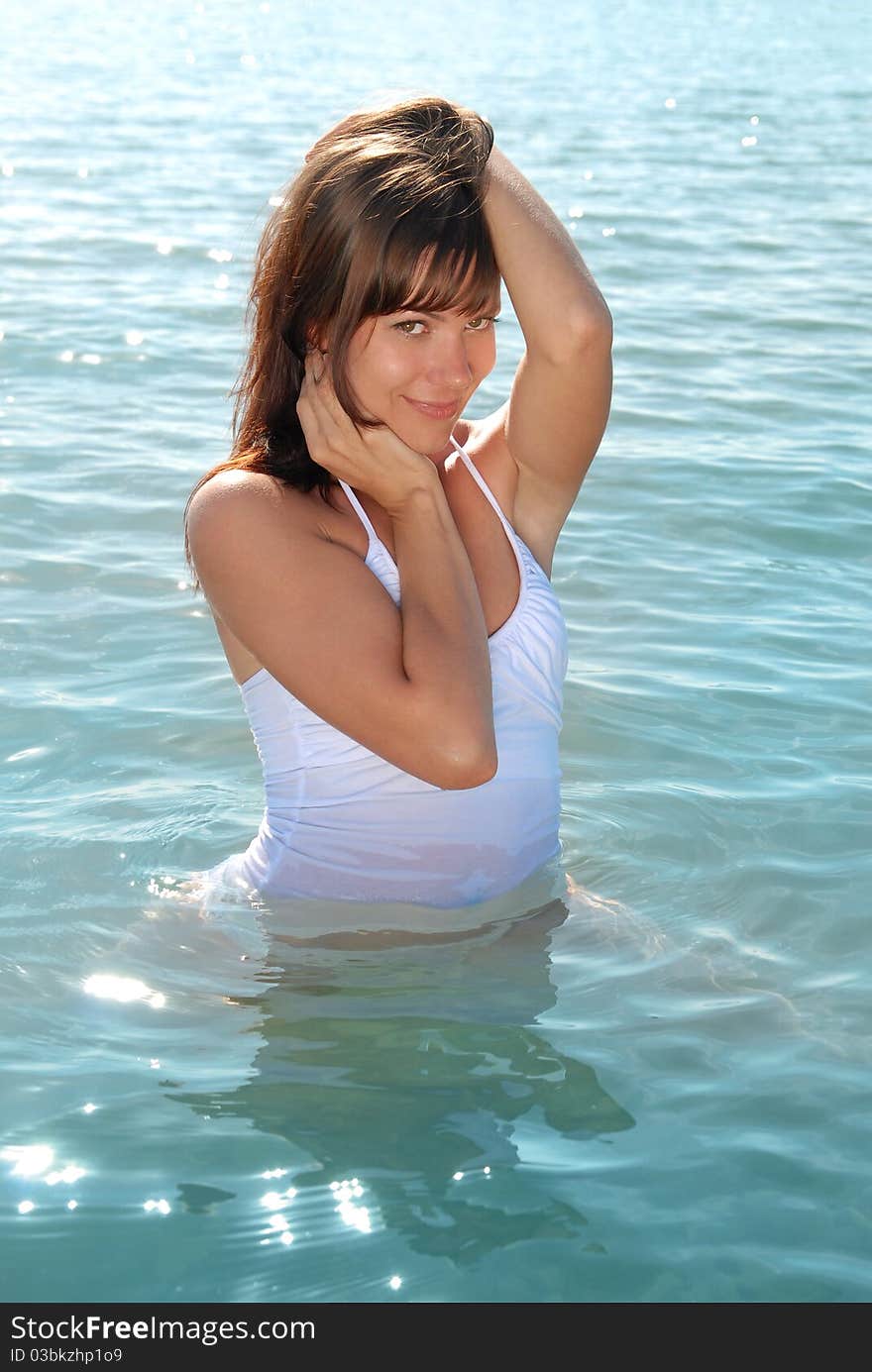 A beautiful young girl smiling sweetly. The girl in the water at the beach. Girl flirts. A beautiful young girl smiling sweetly. The girl in the water at the beach. Girl flirts.