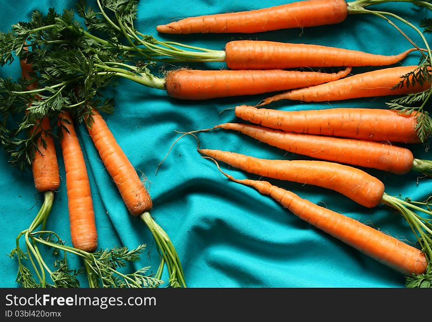 Fresh carrots on blue background.