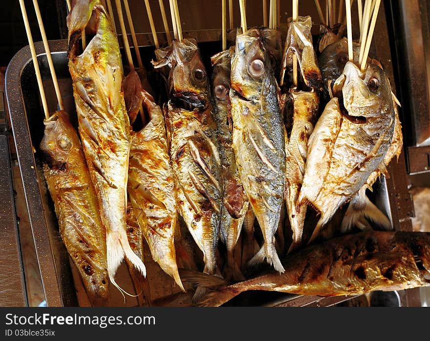 Fish in the sea son with a bamboo stick used to bake wear