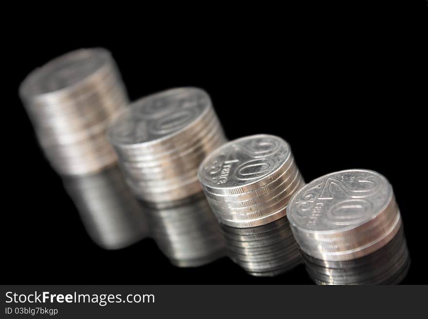 Stack of coins on the black, mirror background. Stack of coins on the black, mirror background