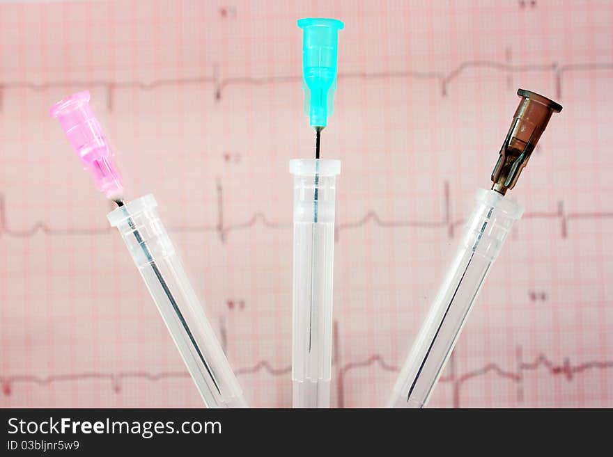 Three needles against an electrocardiogram