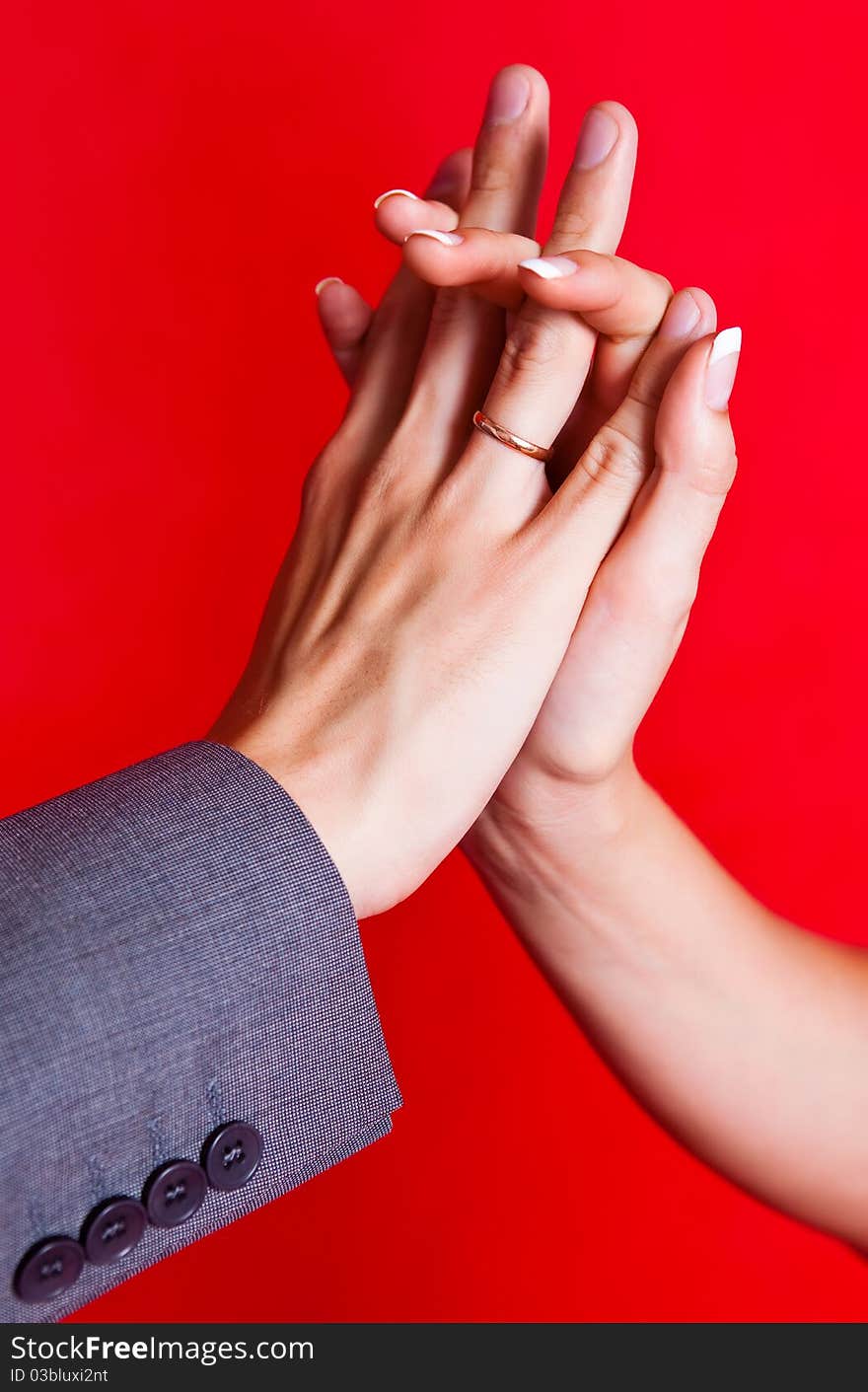 Hands of a bride and a groom with golden wedding rings