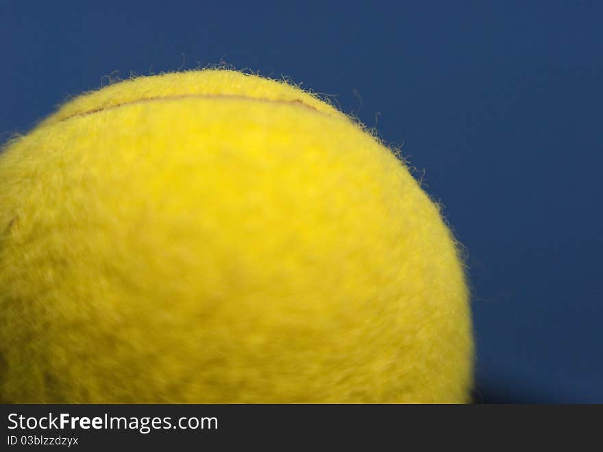 Close-up yellow tennis ball with focus on a small part. Sky blue and copy space. Close-up yellow tennis ball with focus on a small part. Sky blue and copy space.