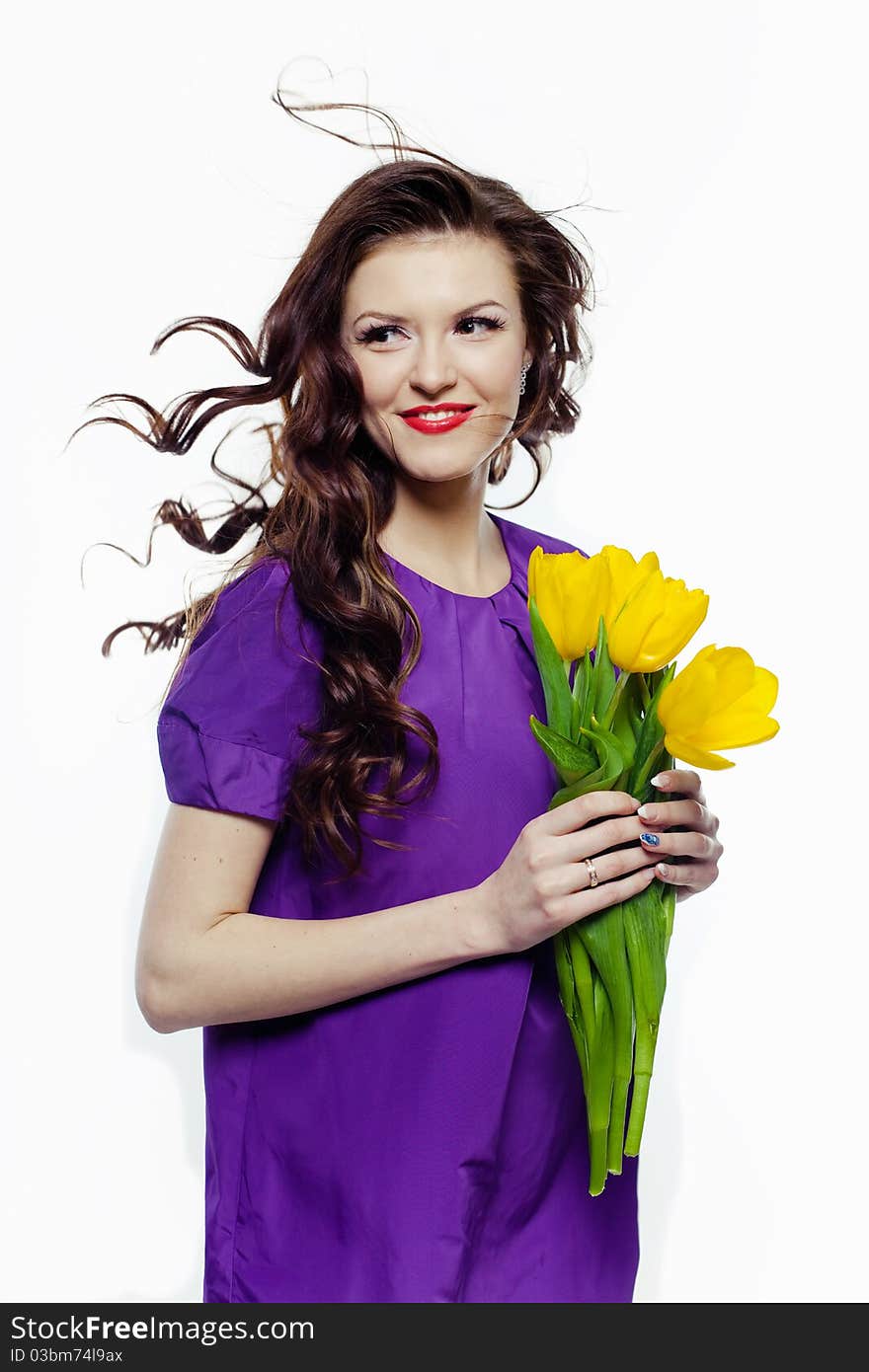 Portrait of a lovely girl with yellow tulips against white background