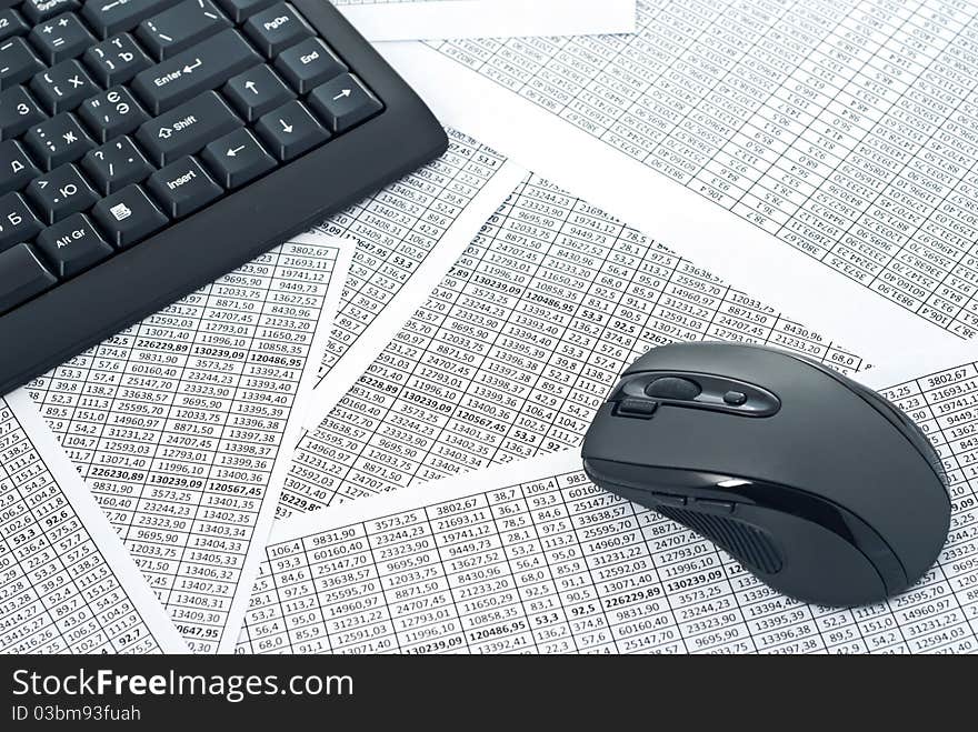 Black keyboard and mouse on a spreadsheets.