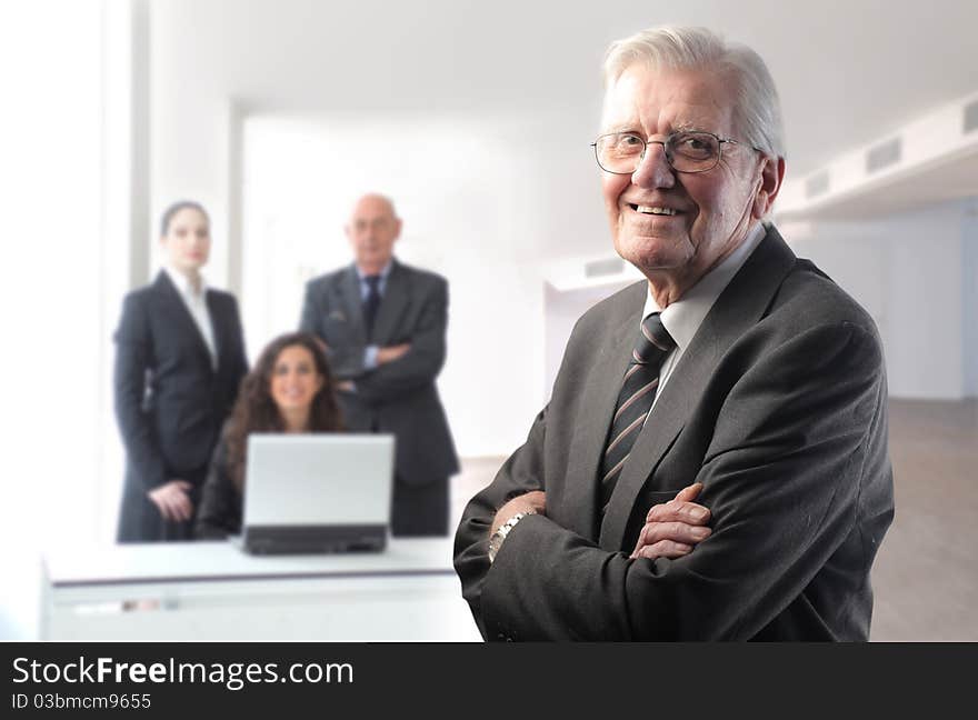 Smiling senior businessman with team on the background. Smiling senior businessman with team on the background