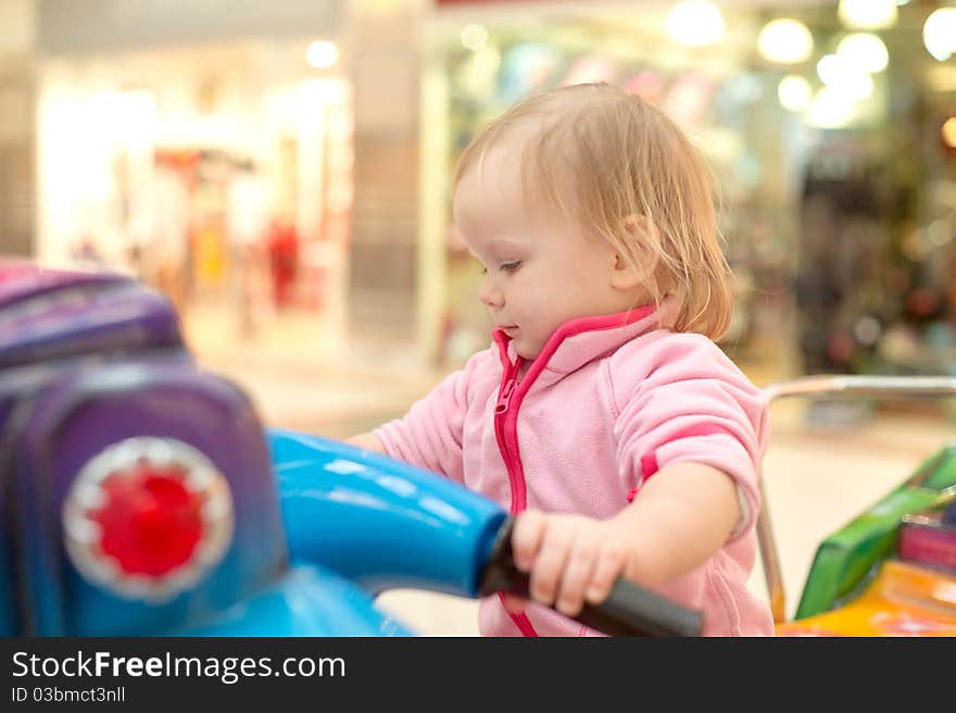 Young adorable baby ride on baby motorcycle in mall