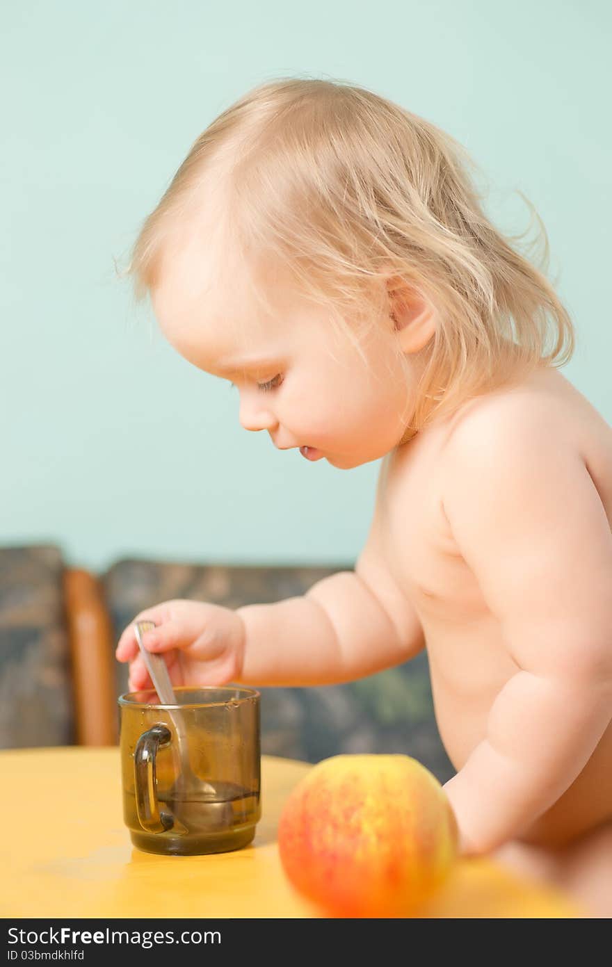 Adorable baby drink a tea with small spoon