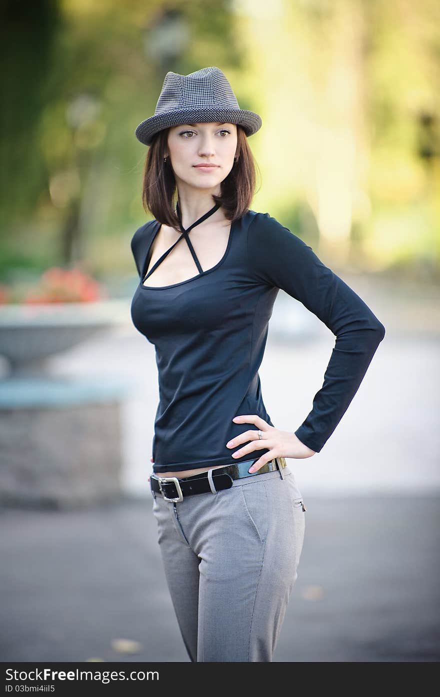 The beautiful girl in a hat stand in the street. The beautiful girl in a hat stand in the street