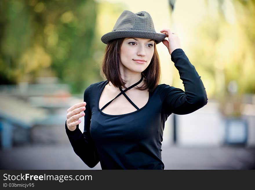 The beautiful girl holds a hat