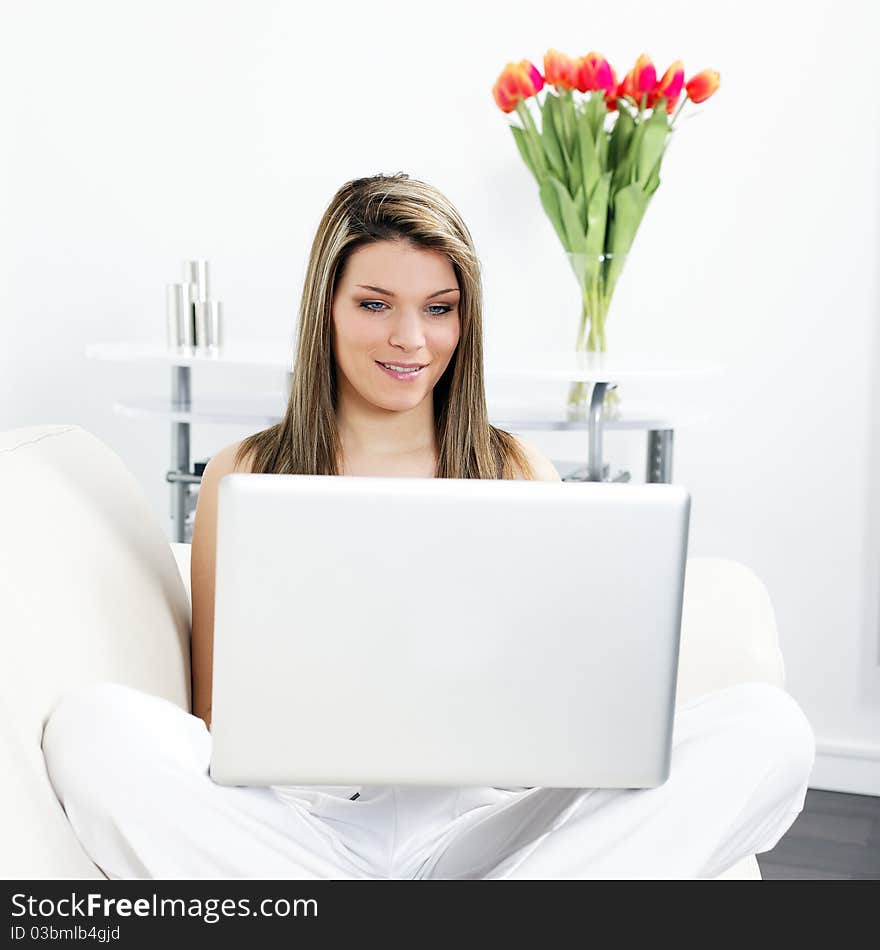 Beautiful blond woman on sofa with computer