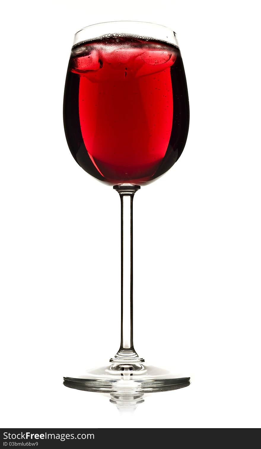 Wine glass with red fruit juice and ice on a white background