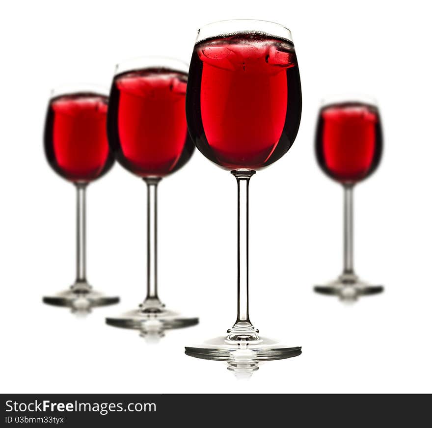 Wine glasses with red fruit juice and ice on a white background