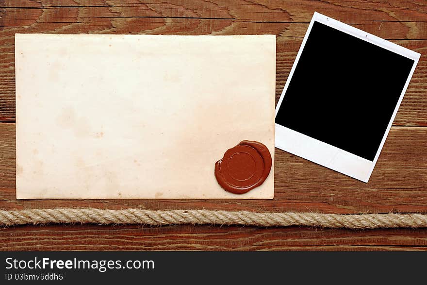 Old paper with a wax seal on a wood background