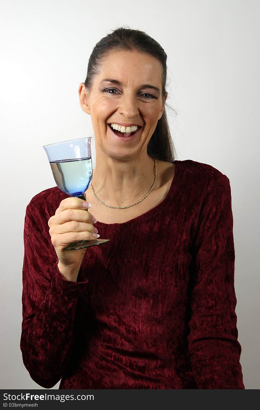 Laughing mature woman in red dress with a glass of white wine. Laughing mature woman in red dress with a glass of white wine