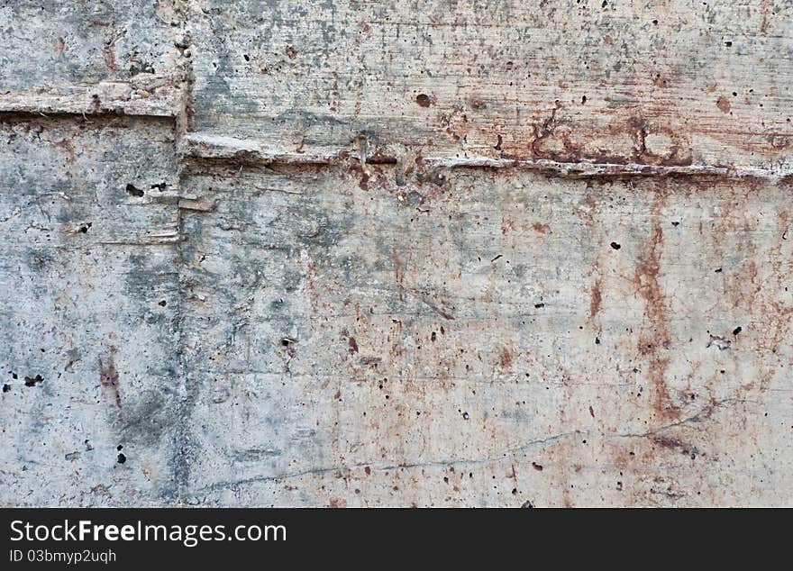 Raw texture of concrete wall with reddish blots