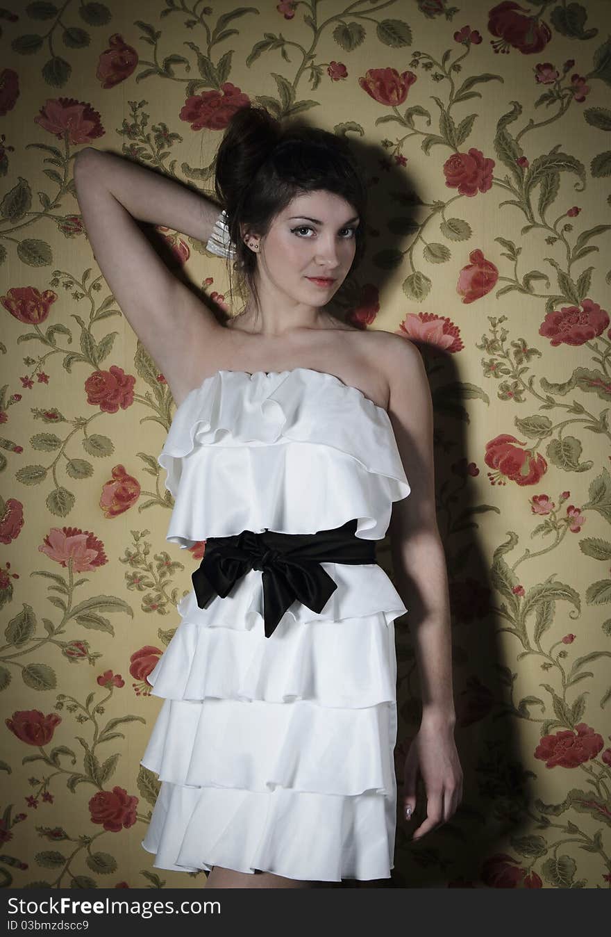 Portrait of the beautiful stylish brunette woman in white dress