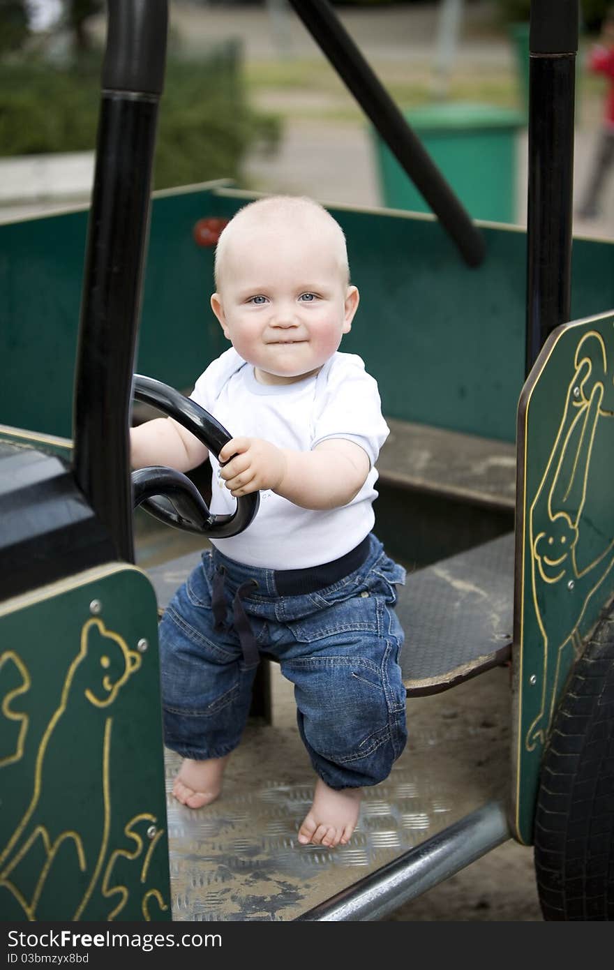 Blond Boy Driving A Toy Car