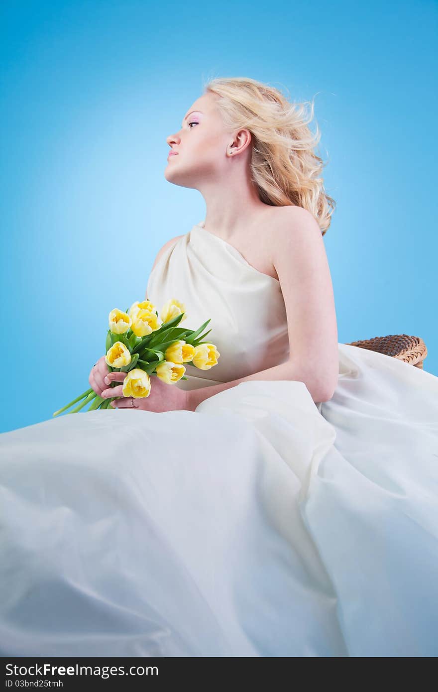 Young beautiful woman with flowing hair holding a bouquet of tulips