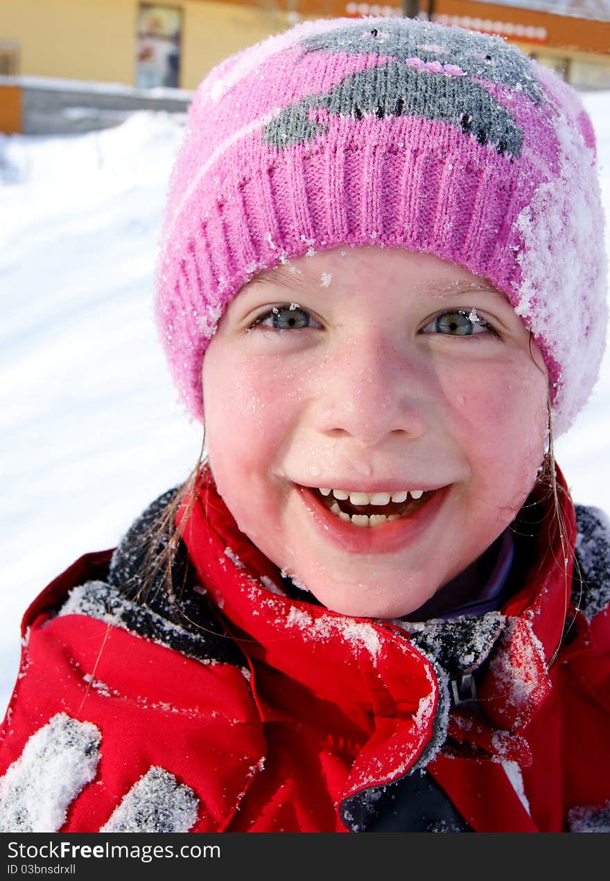 Happy little smiling girl outdoors in the snow in winter clothing. Happy little smiling girl outdoors in the snow in winter clothing