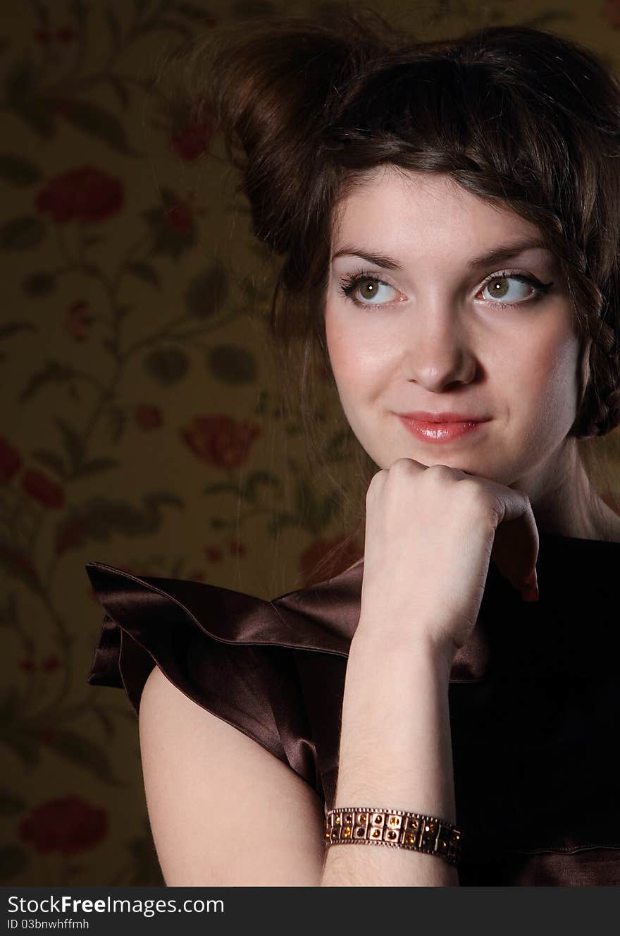 Portrait of the beautiful stylish brunette woman in brown dress