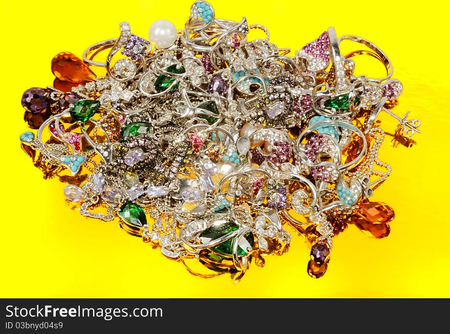 Stack of gold jewelry on a gold background