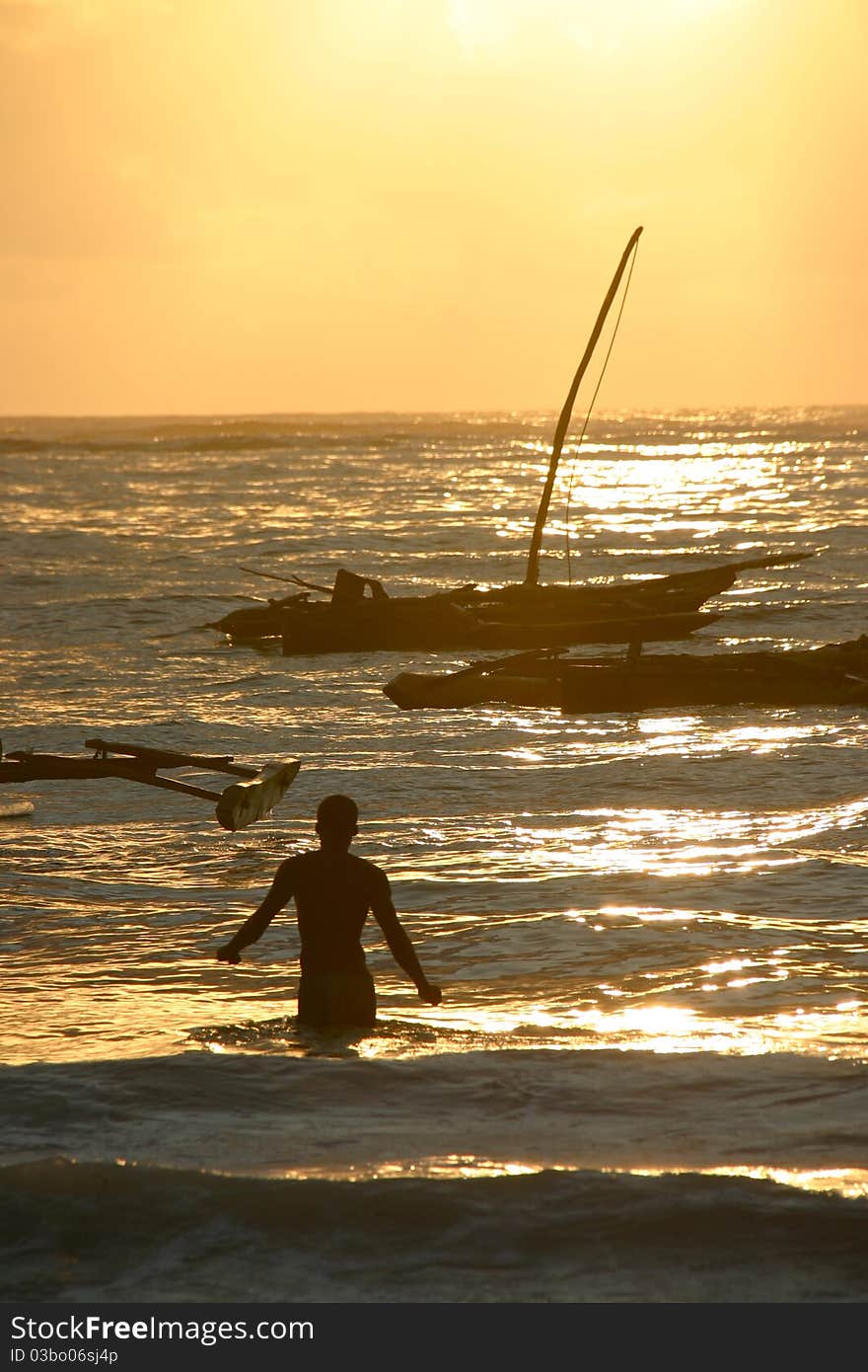 Fisherman And Boat Under Sunrise