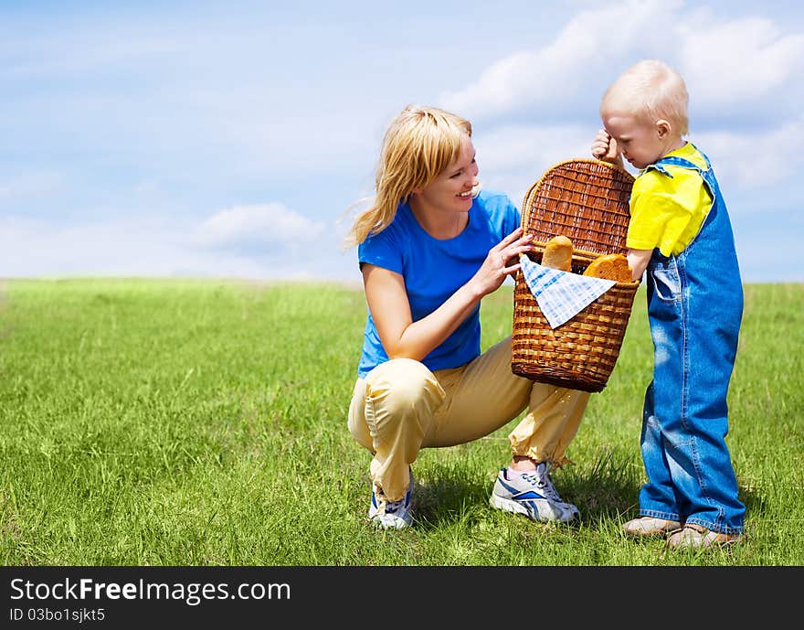 Happy young woman and her son having a picnic outdoor on a summer day. Happy young woman and her son having a picnic outdoor on a summer day