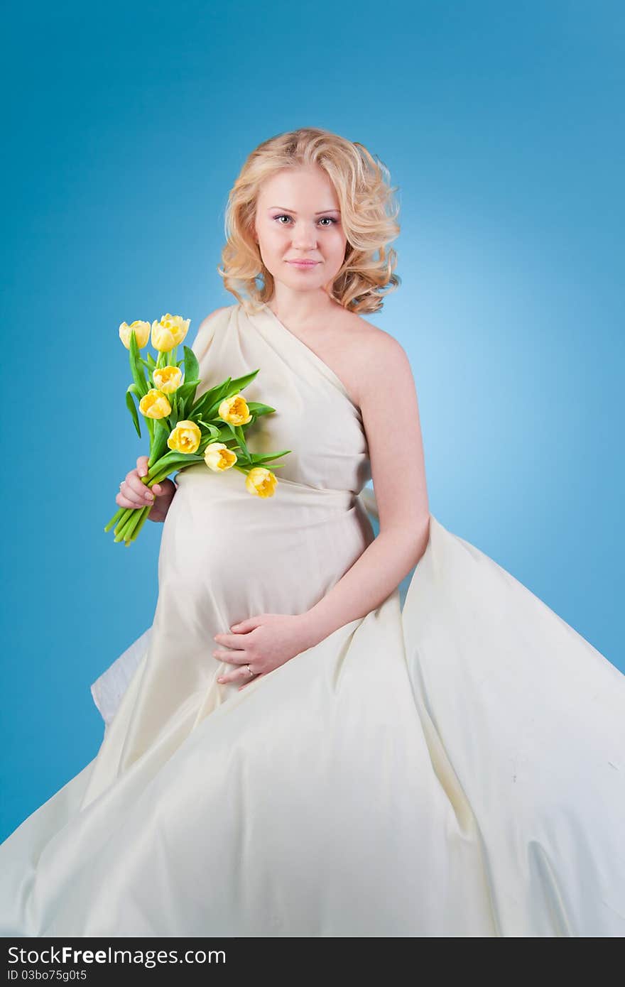 Young beautiful woman with flowing hair holding a bouquet of tulips