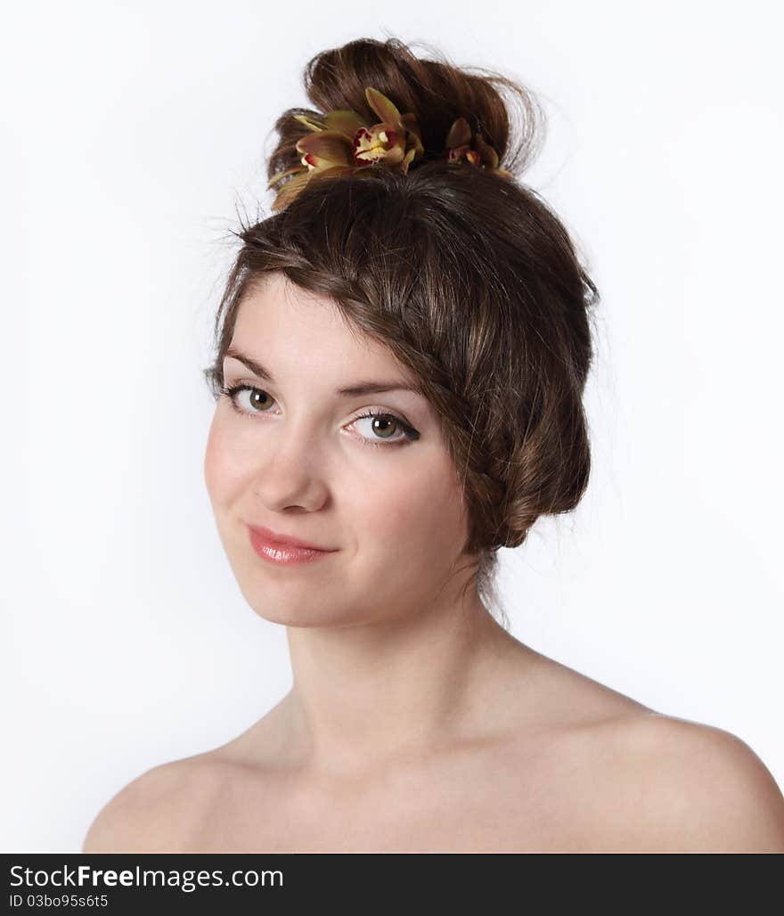 Portrait of the beauty young brunette girl with orchid in her hair