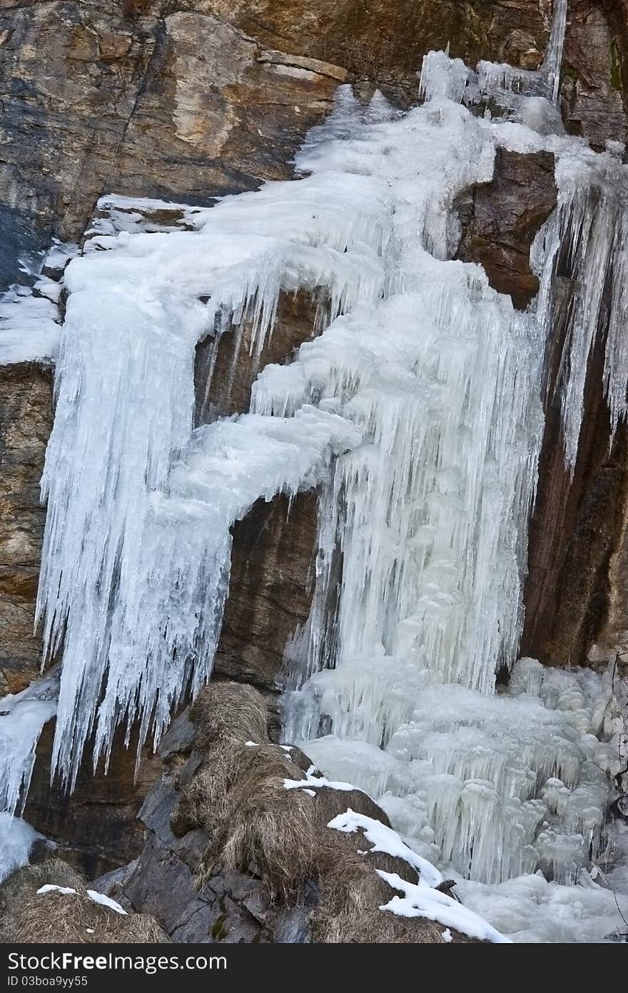 Frost waterfall on rock in Alps mountains