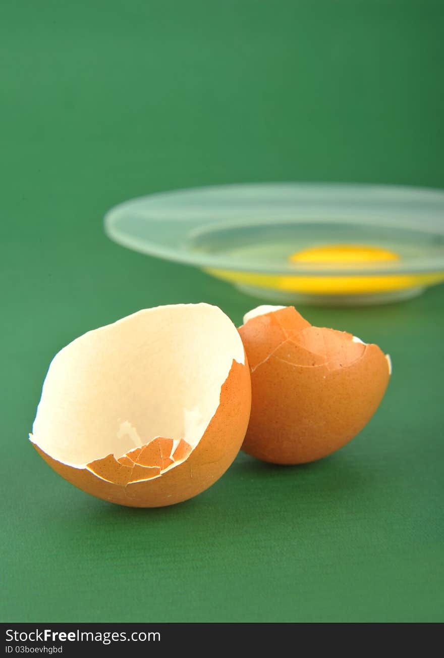 Broken egg isolated on green background