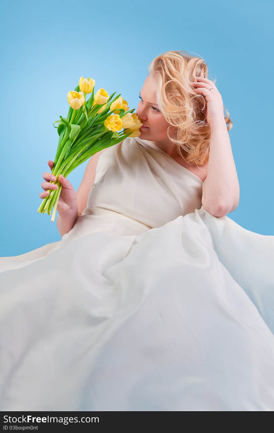 Young beautiful woman with flowing hair holding a bouquet of tulips