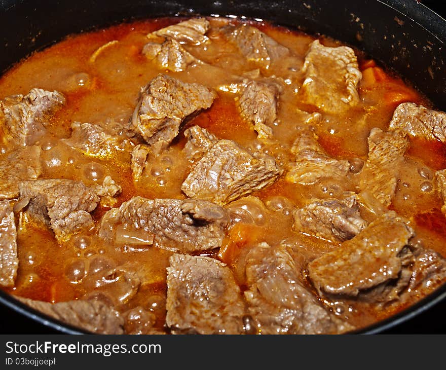 Photo boiling meat in tomato sauce