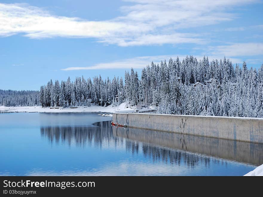 Lake and dam with fresh powder on the surrounding trees. Lake and dam with fresh powder on the surrounding trees