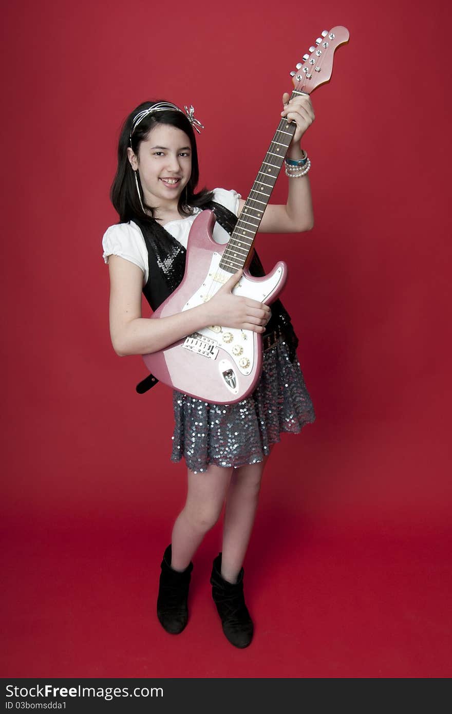 Girl playing pink electric guitar. Girl playing pink electric guitar